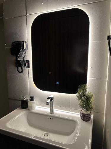 ein Waschbecken mit einem großen Spiegel darüber in der Unterkunft استديو هادئ بدخول ذكي in Ar Rass