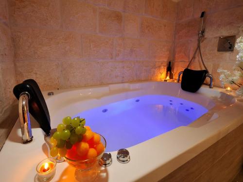 a bathroom with a tub with a bowl of fruit at Zimmer BaSadot in Yavneʼel