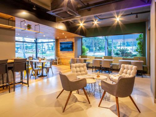 um restaurante com mesas e cadeiras em uma sala em Mercure Florianópolis em Florianópolis