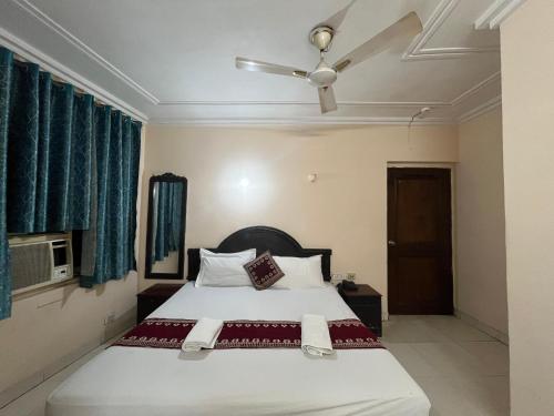 Hotel RS international Couple Friendly في نيودلهي: غرفة نوم بها سرير ومروحة سقف