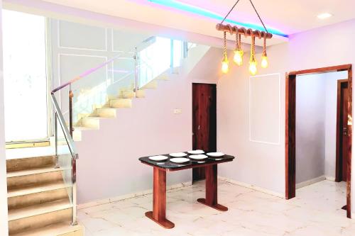 een kamer met een tafel en een trap bij ll EMPYREAN STAY ll SUPREME VILLA ll 3BHK II PVT POOL II MINI BAR AREA II AC in Lonavala