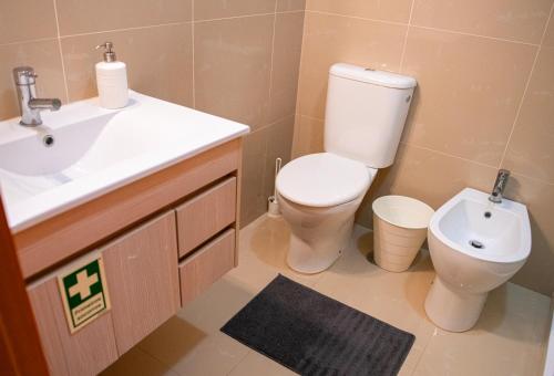 a bathroom with a toilet and a sink at Meio Mundo in Várzea