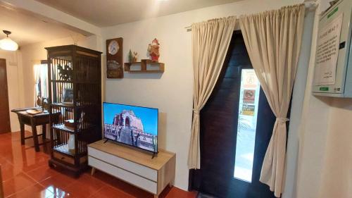 a living room with a flat screen tv next to a window at Koala's Nest in Chiang Mai