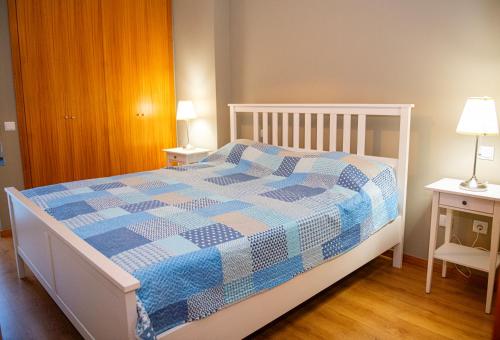 a bedroom with a bed with a blue and white quilt at Meio Mundo in Várzea
