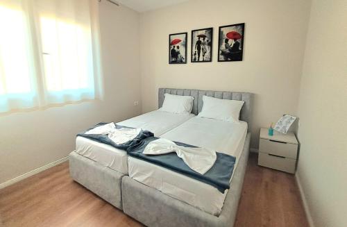 una camera da letto con un letto grande con due quadri sul muro di Harmony BnB a Tirana