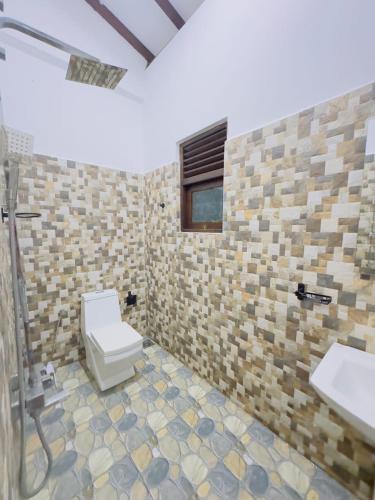 a bathroom with a toilet and two sinks at Moonlit serenity Tangalle in Tangalle
