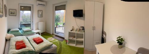 una pequeña sala de estar con cama y TV. en Korzó Terasz Szentendre, en Szentendre