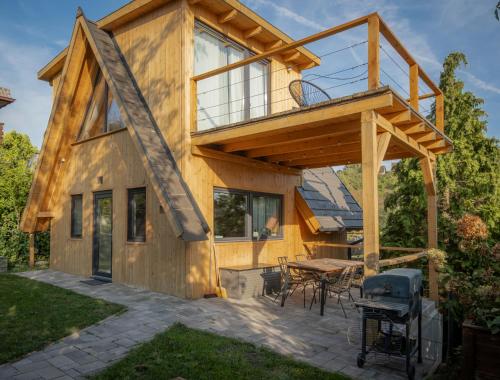 a house with a deck with a table and a grill at Zebi vendégház in Zebegény