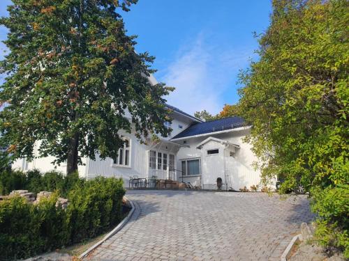 a white house with a cobblestone driveway at Room in exclusive villa in sentral Oslo in Oslo