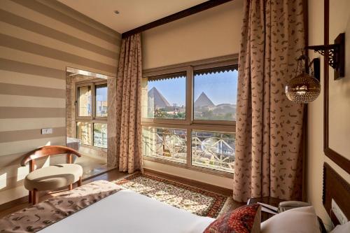 a bedroom with a large window with a view of the pyramids at 7 Gates Boutique Hotel Pyramids in Cairo