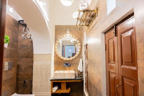 ein Badezimmer mit Waschbecken und Spiegel in der Unterkunft Jeevan Haveli Heritage Hotel & Museum in Nawalgarh