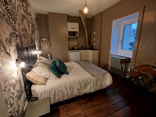 a small bedroom with a bed with green pillows at La maison de famille Limoges in Limoges