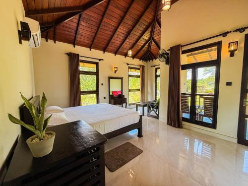Un dormitorio con cama, escritorio y ventanas en Go Yala Hostel, en Tissamaharama