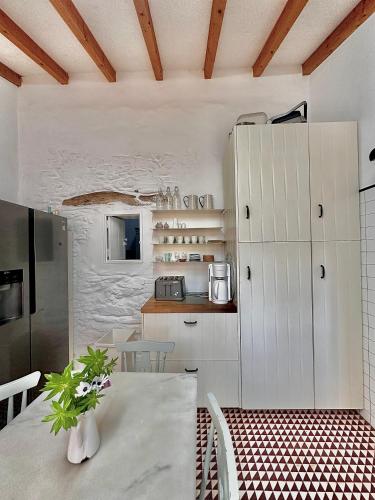 a kitchen with white cabinets and a table at Casa no Montinho in Ourique
