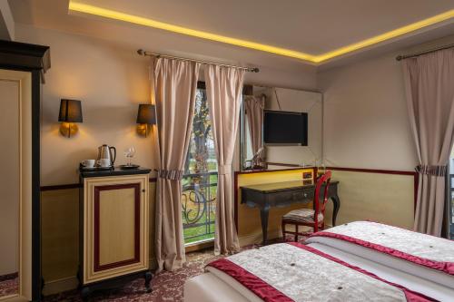 een slaapkamer met een bed, een bureau en een raam bij Domeniile Martinutzi - Hotel Cardinal in Alba Iulia