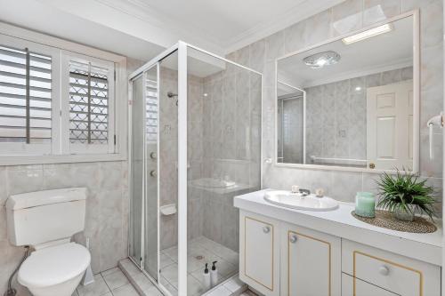 een badkamer met een toilet, een wastafel en een douche bij Waterfront entertainers dream with private beach in Gold Coast