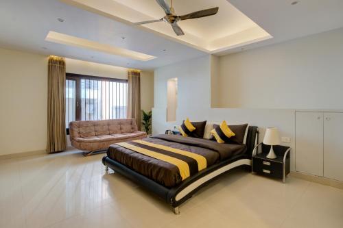 Un dormitorio con una cama grande y un sofá. en The Grand Rustam Villa, en Gurgaon