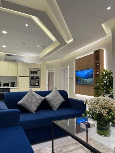 ein Wohnzimmer mit einem blauen Sofa und einem Glastisch in der Unterkunft شقق نطوان المفروشة in Abha