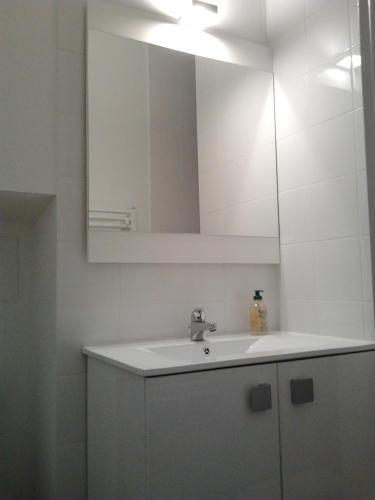 une salle de bain blanche avec un lavabo et un miroir dans l'établissement Cielito Lindo, à Montpellier
