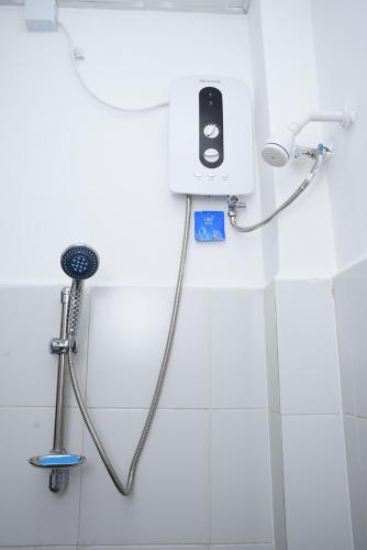 a shower in a bathroom with a phone on the wall at Colombo Mount Hostel in Mount Lavinia