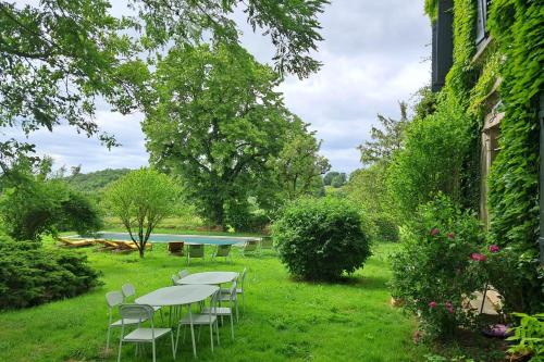 un grupo de mesas y sillas en el césped en Paradis en Berry, en Le Pêchereau