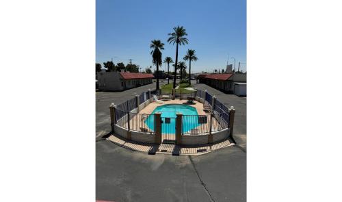 een zwembad op een parkeerplaats met palmbomen bij Del Rio Hotel O near Mesa Downtown in Mesa