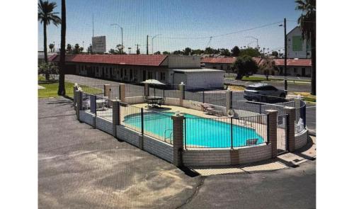 een hek rond een zwembad op een parkeerplaats bij Del Rio Hotel O near Mesa Downtown in Mesa