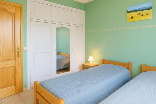 una camera da letto con due letti e uno specchio di Gîte le Platane a Montagnac