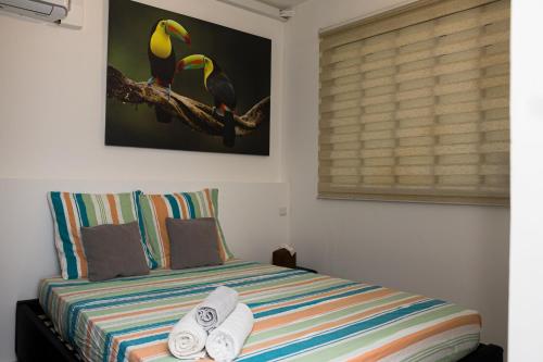 a bedroom with a bed with towels on it at Cocon Madeleine Confort et piscine wifi et climatisation in Cayenne