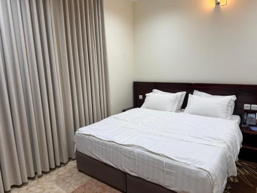 a bedroom with a bed with white sheets and white pillows at Sanabel ALmshaan Hotel in Al Wudayy