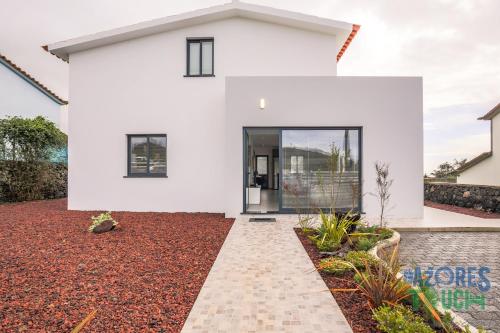 a white house with a pathway in front of it at Silver Gate Home in Cinco Ribeiras