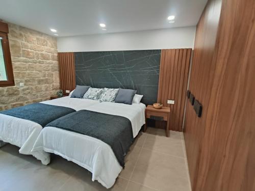 een slaapkamer met een groot bed en een stenen muur bij Casa Rural Del Valle Estrecho 