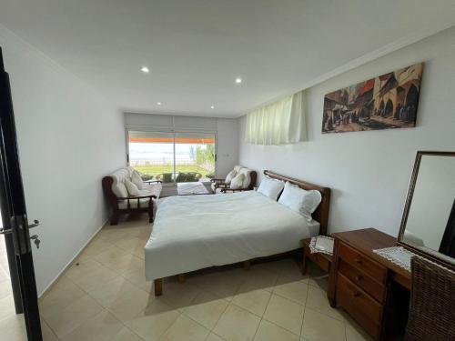 Maison Bord de Mer Skhirate في الصخيرات‎: غرفة نوم مع سرير وغرفة معيشة