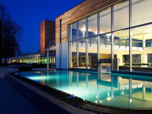 Aspria Hannover Maschsee Sport & Spa في هانوفر: مبنى به حمام سباحة أمام المبنى