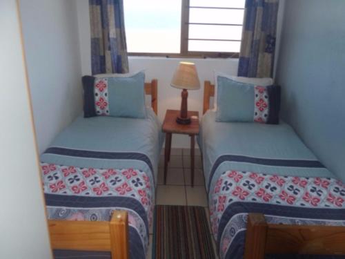 a room with two beds and a table with a lamp at Villa Siesta Flat No 5 in Margate