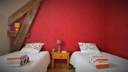 two twin beds in a room with red walls at "Chambre 2", Ferme de la Volière in Gidy