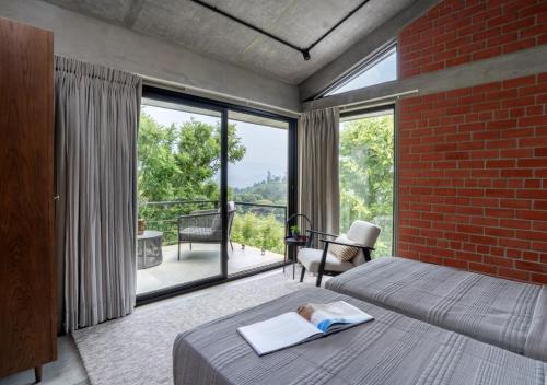 ein Schlafzimmer mit einem Bett und einer Ziegelwand in der Unterkunft LohonoStays Villa Amani 8B in Coonoor