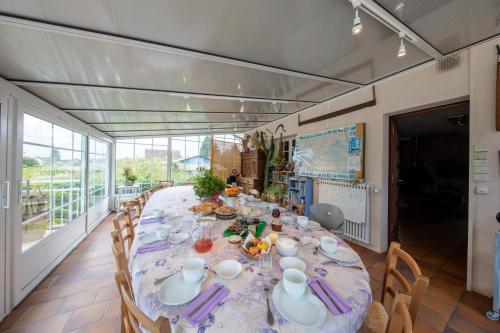 ein Esszimmer mit einem langen Tisch und Stühlen in der Unterkunft "Chambre Lorris", Ferme de la Borde in Saint-Benoît-sur-Loire
