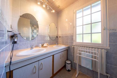 a bathroom with two sinks and a window at "Chambre Lorris", Ferme de la Borde in Saint-Benoît-sur-Loire