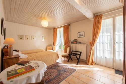 a bedroom with two beds and a large window at "Chambre Lorris", Ferme de la Borde in Saint-Benoît-sur-Loire