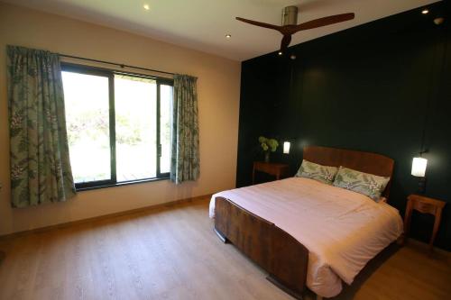 a bedroom with a bed and a large window at Chambre "Argentine", Le Clos des Poulies in La Ferté-Saint-Aubin