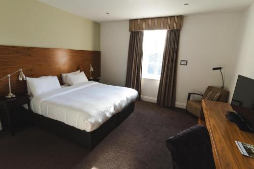 a hotel room with a large bed and a desk at Aston Hall Hotel, BW Signature Collection in Sheffield