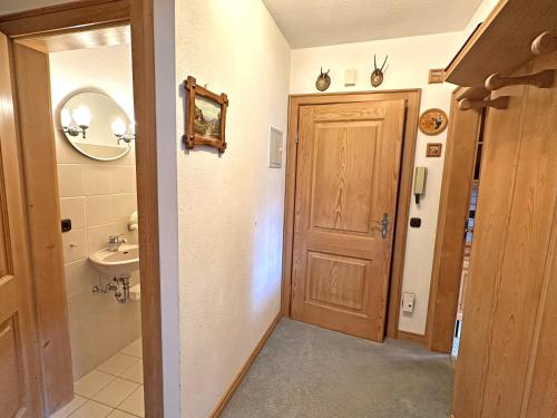 een badkamer met een houten deur en een wastafel bij Gschwendtnerhof App5 Pätzig in Aschau im Chiemgau
