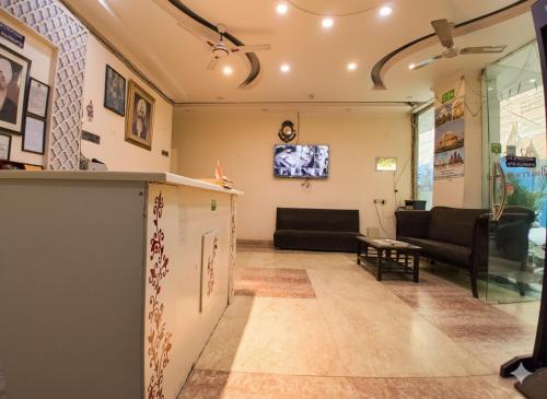 Hotel RS international Couple Friendly في نيودلهي: غرفة معيشة مع أريكة وتلفزيون