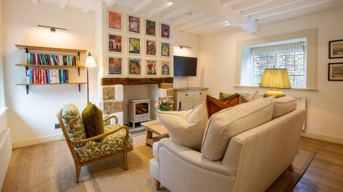 een woonkamer met een bank en een open haard bij Oak Cottage in Swerford