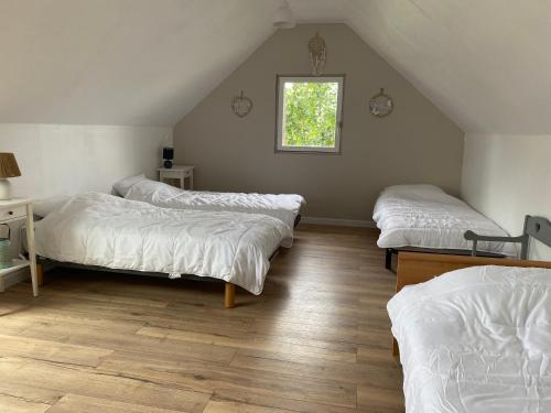 Zimmer im Dachgeschoss mit 3 Betten und einem Fenster in der Unterkunft L'orée du bois in Saint-Valery-sur-Somme