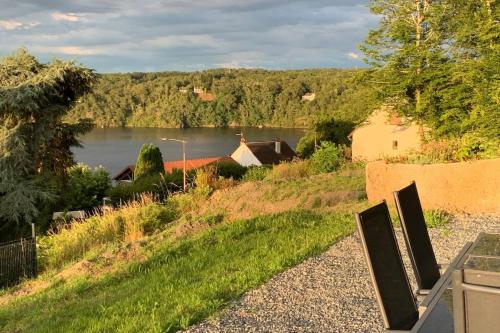 a view of a lake and a house on a hill at Les hauts du lac - 500 m du lac - Vu sur le lac in Éguzon-Chantôme