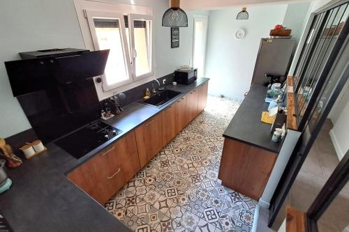 an overhead view of a kitchen with a sink and refrigerator at Les hauts du lac - 500 m du lac - Vu sur le lac in Éguzon-Chantôme