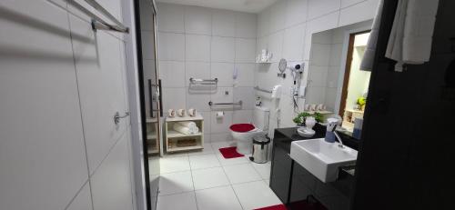 ein weißes Badezimmer mit Toilette und Waschbecken in der Unterkunft Top Apartamento Studio Iloa Residence in Barra de São Miguel