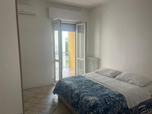 een slaapkamer met een bed en een deur naar een balkon bij Emy House in Azzano San Paolo